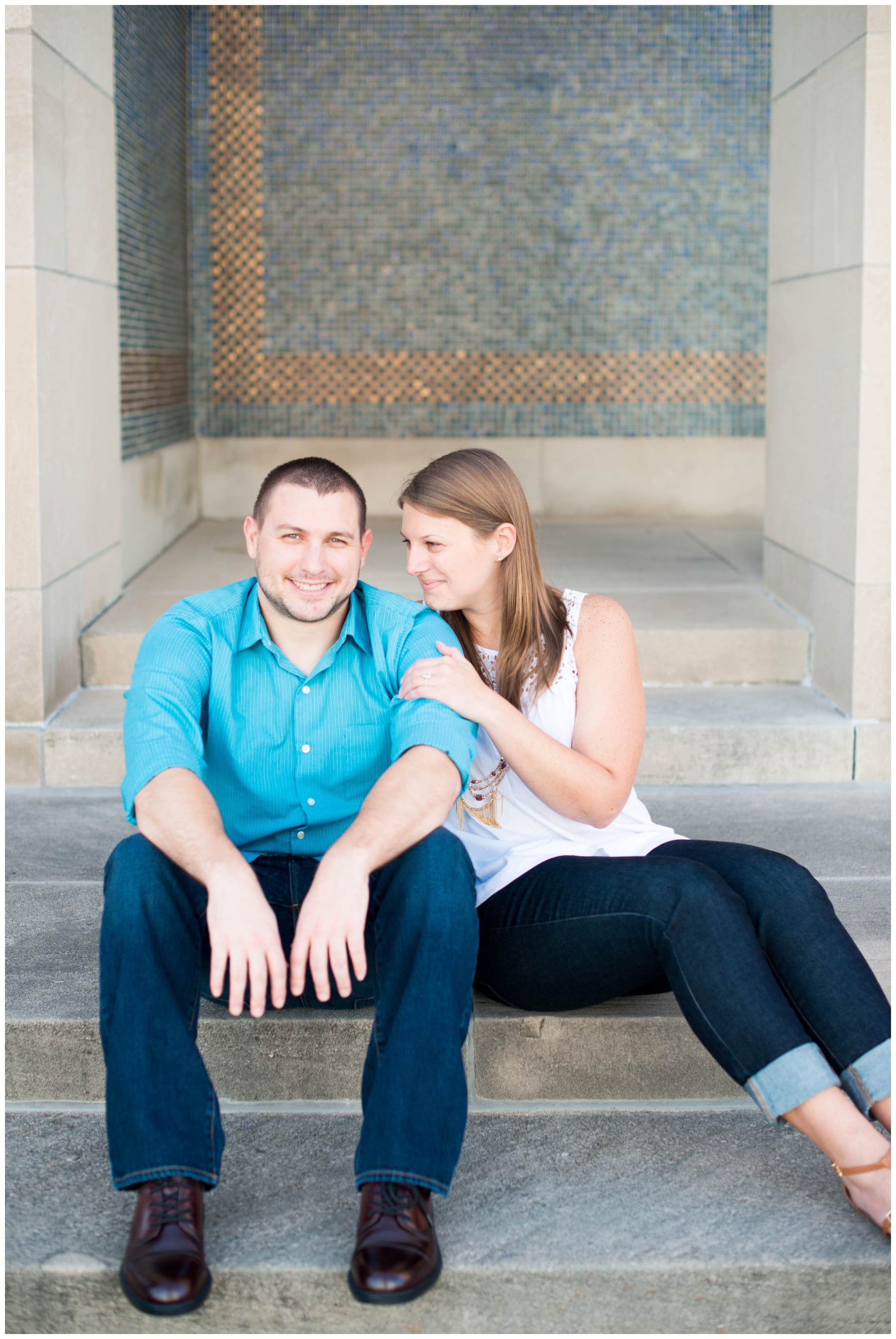 Engagement pictures downtown Kansas City at Liberty Memorial with floral dress and mustard yellow cardigan, fountains and tiled walls with city scape by photographer Lacey Rene Studios
