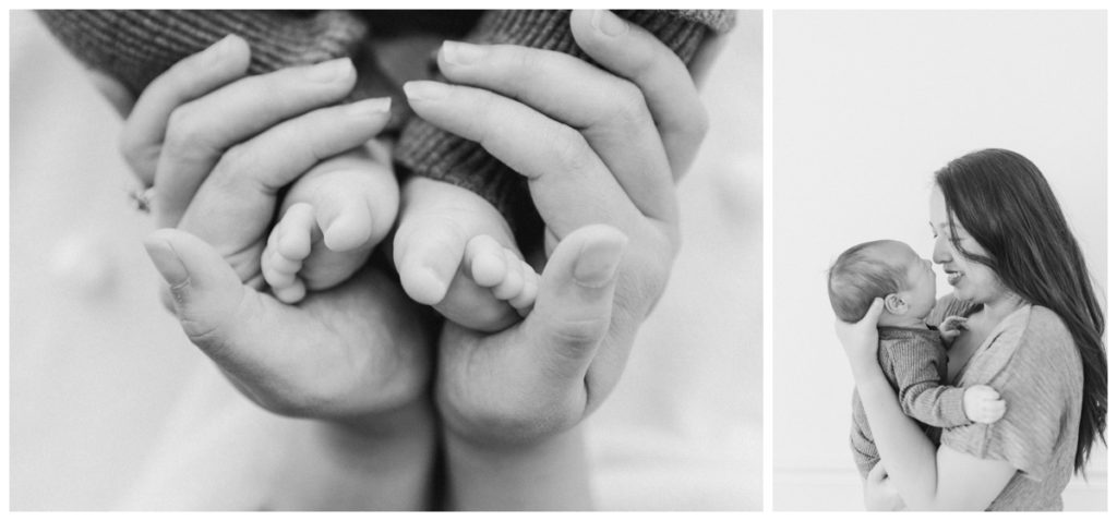 A close up black and white photo of a mother's hands wrapped around the toes of her newborn son.