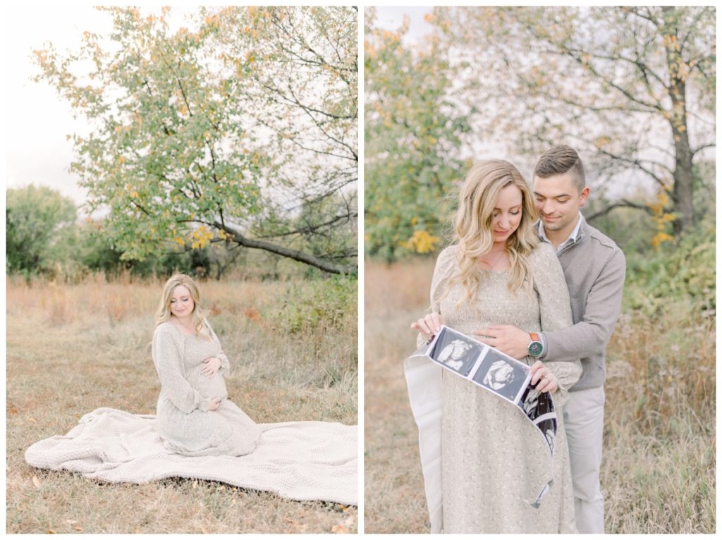 Maternity photo of a young couple standing in a field with Fall colors holding their ultrasound photos. 