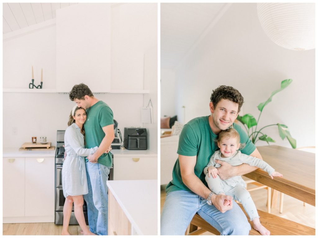 Photo of a young dad with curly dark hair holding his daughter on his lap in a white kitchen while they sit at the bench of their kitchen table smiling at the camera. 