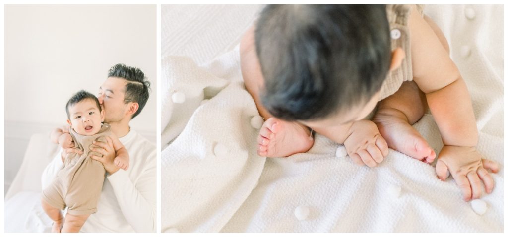 Photo taken from above of a baby's hands and toes grasping a cream blanket. 